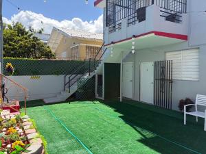 ein kleiner Hof mit Rasen vor einem Haus in der Unterkunft Mini Studio Apartment in San Juan