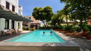 a swimming pool with two people in the water at Unity Villa Staycation -Self Checkin in Hoi An