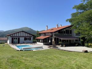 a house with a swimming pool in the yard at Arlotia in Ascarat
