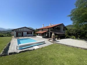 a house with a swimming pool in front of it at Arlotia in Ascarat