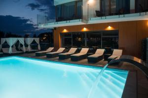 a swimming pool with lounge chairs next to a building at Stella APART Resort & SPA in Władysławowo