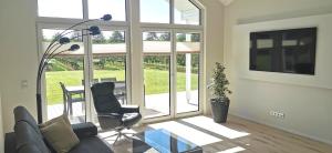 a living room with a glass table and chairs at Ferienhaus Elbdeichblick 2 in Haselau