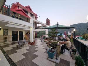 a person sitting at a table on a balcony at Hotel Biaspushp Dalhousie in Banikhet