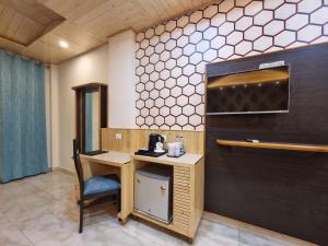 a room with a desk and a chair in a room at Hotel Biaspushp Dalhousie in Banikhet