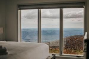 a bedroom with a large window looking out at the mountains at Mountain View Vista in Mount Torry Furnace