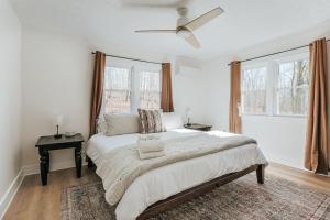 a white bedroom with a bed and a ceiling fan at Nelson Cozy Cabin in Nellysford
