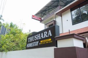 a sign for a restaurant on the side of a building at Thushara Homestay in Kozhikode