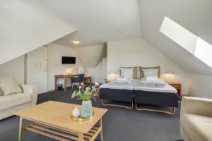 a bedroom with a bed and a living room at Skjoldbjerg Garnihotel in Vorbasse