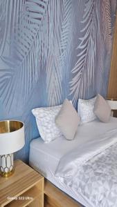 a bed with two pillows and a wall with palm leaves at Beas Place Klong Dao in Ko Lanta +100 photos