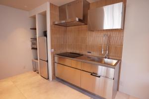 a small kitchen with a sink and a refrigerator at TABISAI HOTEL Premium 博多-中洲 in Fukuoka