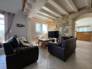 a living room with two leather chairs and a tv at Juanttipienea in Souraïde