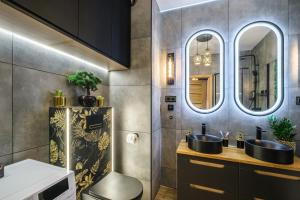 a bathroom with two sinks and two mirrors at Golden Eagle Luxury Apartment - Granary Island- Gdańsk Old Town in Gdańsk +20 photos