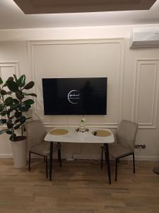 a living room with a table and chairs and a tv at Blue Perła Premium in Kutno