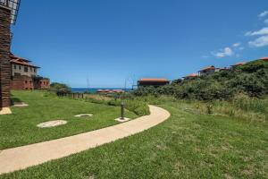 a path leading to a house with the ocean in the background at Zimbali Suites 110 in Ballito