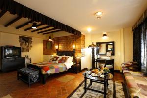 a bedroom with a bed and a tv and a couch at Hotel Heritage in Bhaktapur