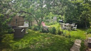 a yard with a table and chairs and a fence at Golf&Love in Normandy in Sainte-Opportune-du-Bosc