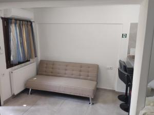 a couch sitting in a room with a piano at AFRODITE in Diakopto