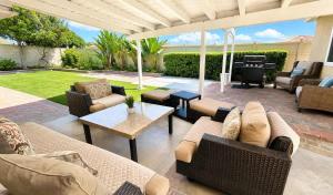 a patio with couches and a table and a grill at Disneyland Dream Villa 5 BR 3 BA Arcade Games in Anaheim +46 photos