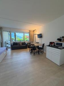 a living room with a couch and a table with chairs at Holiday on the Lake Lugano in Bissone