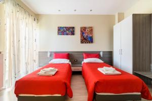 two beds in a room with red sheets and towels at 85Centro in Potenza