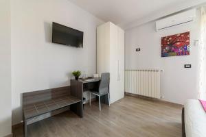 a living room with a desk and a television on a wall at 85Centro in Potenza
