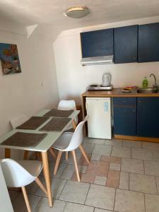 a kitchen with a table and chairs and a refrigerator at Hotel Antonios in Pythagoreio