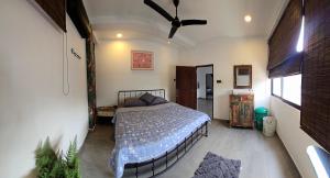 a bedroom with a bed and a ceiling fan at Urban tropics in Colombo