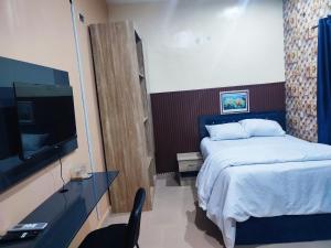 a bedroom with a bed and a flat screen tv at Regent Hotels and Suites in Oshogbo