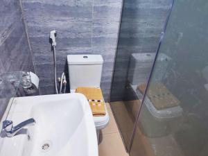 a bathroom with a toilet and a sink and a shower at Regent Hotels and Suites in Oshogbo