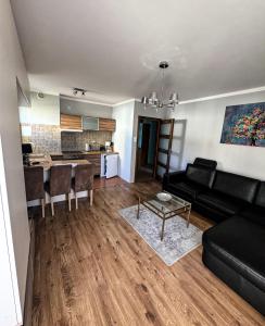 a living room with a black couch and a table at The Third Six in Świnoujście