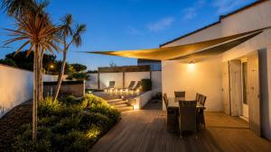 a wooden deck with a table and chairs on a house at Villa Odys in Rivedoux-Plage