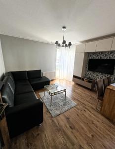 a living room with a black couch and a table at The Third Six in Świnoujście