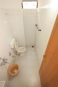 a small bathroom with a toilet and a sink at JK Residency in Pondicherry +21 photos