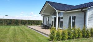 a house with a wooden deck next to a yard at Ferienhaus Elbdeichblick 2 in Haselau