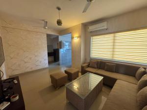 a living room with a couch and a coffee table at Pindora Stays in Ludhiana