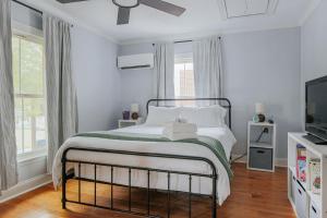 a white bedroom with a bed and a television at The Wayne Shire in Waynesboro