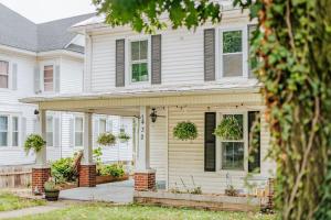 a white house with a porch with potted plants at The Wayne Shire in Waynesboro