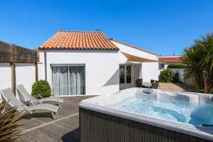 a hot tub on the deck of a house at Villa Odys in Rivedoux-Plage