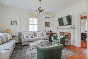 a living room with a couch and chairs and a fireplace at The Woodward in Staunton