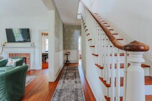a staircase in a living room with a green couch at The Woodward in Staunton