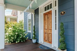 a blue house with a wooden door on a porch at The Woodward in Staunton
