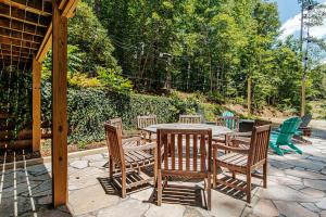 a wooden table and chairs on a stone patio at Tucked Inn: Lower Unit in Nellysford