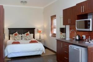 una piccola camera da letto con un letto e una cucina di Yellow Aloe a Clanwilliam