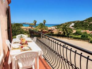 a table on a balcony with a view of the ocean at Piazzetta Dei Pini Two Bedroom Apartment 100 m from the Beach in Baja Sardinia