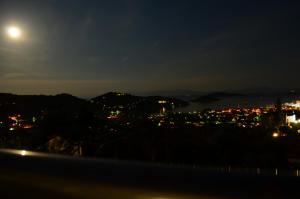 a view of a city at night with the moon at Villas Zoe in Skiathos