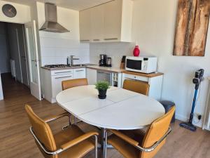 a kitchen with a table and chairs in a room at Sealview Nevada in Koksijde
