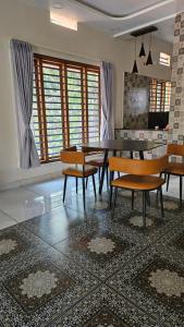 a dining room with a table and chairs on a rug at Aadhya Serenity - Private Villa near Ecobeach Honnavar in Honāvar +24 photos