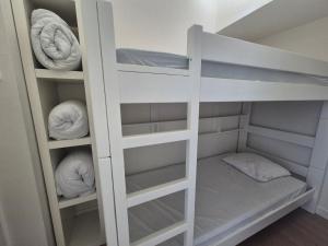 a white bunk bed with white shelves and pillows at Sealview Nevada in Koksijde