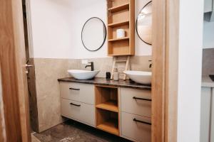 a bathroom with two sinks and two mirrors at Longaview in Weisspriach +44 photos