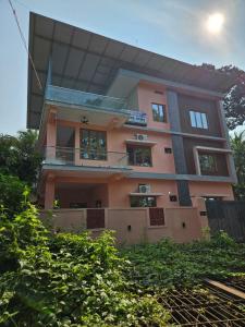 a pink building with a balcony on top of it at Aadhya Serenity - Private Villa near Ecobeach Honnavar in Honāvar
